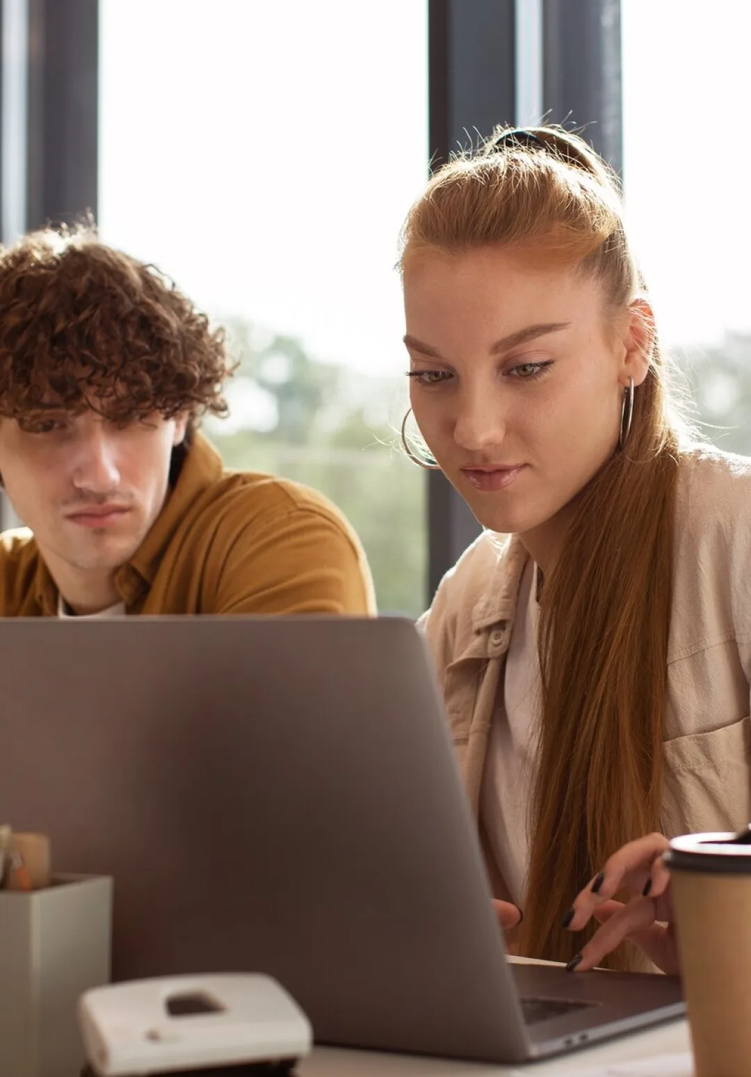 Two people working side by side at a laptop
